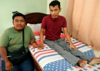 MOHAMAD Amyrul Asraf Zulkifli (kiri) menjaga adiknya yang lumpuh, Shahnazali ketika kunjungan Utusan Malaysia di rumah mereka di Kampung Segajop, Pasir Salak semalam. - FOTO/AIN SAFRE BIDIN