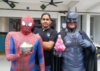 MUHAMMAD Razi Muhammad Rafiq (tengah) bersama dua pekerjanya yang memakai kostum adiwira Batman dan Spiderman di depan Restoran Haji Baba, Bandar Sri Sendayan, Seremban. - UTUSAN/ZAKKINA WATI AHMAD TARMIZI.