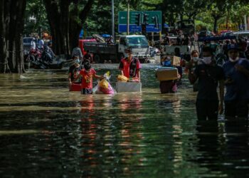 Mangsa-mangsa banjir meredah air untuk pulang ke rumah  yang ditenggelami air untuk melihat  barangan yang boleh diselamatkan di Taman Sri Muda, Shah Alam Selangor pada 20 Disember 2021. -UTUSAN/AFIQ RAZALI