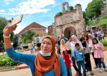 PENGUNJUNG tidak melepaskan peluang bergambar di Kota A'Famosa, Banda Hilir, Melaka. UTUSAN/RASUL AZLI SAMAD