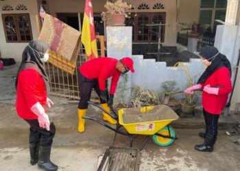 SUKARELAWAN  Agrobank membersihkan kawasan rumah mangsa banjir di Hulu Langat, Selangor.