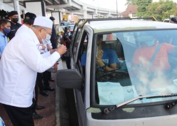 AHMAD Yakob menyapa pengguna jalan raya ketika turun padang di lokasi sekatan jalan raya di Jambatan Sultan Yahya Petra, Kota Bharu, Kelantan hari ini. - FOTO/ZULHANIFA SIDEK