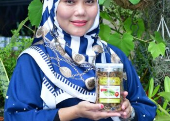 AELIS Malina Ahmad bersama produk Peria Crispy yang dihasilkan olehnya.