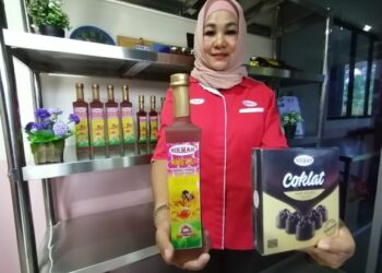 SALMAH menunjukkan produk madu kelulut yang diusahakannya di bawah jenama Nikmah di Tuaran baru-baru ini.