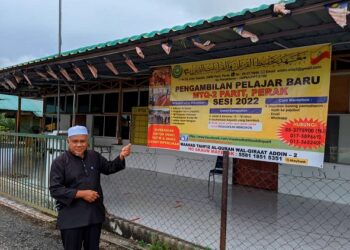 MOHD. Alwi Mohd. Isa menunjukkan poster pengambilan pelajar bagi sesi 2022 ketika ditemui di Parit, Perak. - UTUSAN/MOHAMAD HAFIZI MOHD. SAID