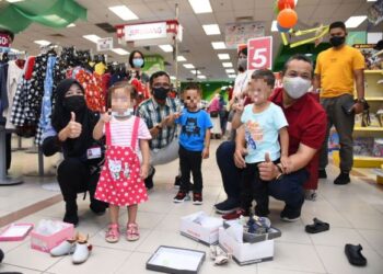 AMINUDDIN Harun (kanan) memberikan kasut baharu kepada anak-anak klien AADK sempena Program Integrasi Sosial dan Outreach Rujukan Raya Tanpa Covid-19 bersama AADK di Seremban 2, Seremban hari ini. - FOTO/ZAKKINA WATI AHMAD TARMIZI