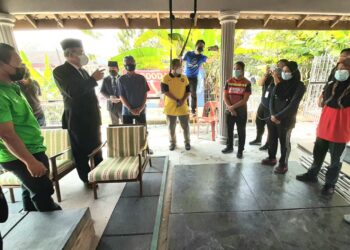 TUN Mohd. Ali Mohd. Rustam (dua, kiri) memberi kata-kata semangat kepada sebahagian daripada enam atlet remaja yang dilatih Ahmad Janius Abdullah (kiri) di Kampung Kesang Tua, Jasin, Melaka semalam. –  UTUSAN/AMRAN MULUP