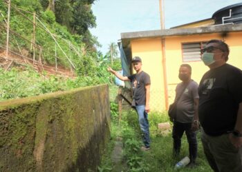 ASNUDI Mohd. Ashaari (kiri), Muhammad Arif (tengah) dan Zool Amali menunjukkan projek pembaikan cerun runtuh di Rumah Rakyat Panchor, Seremban yang dijalankan tanpa sebarang perbincangan dengan penduduk.