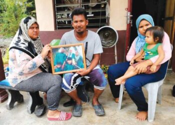 ZURAIDAH Md. Ali (kiri) dan suaminya, Mohd. Fadzil Mohamad menunjukkan gambar kenangan mereka bersama tiga anak mereka yang meninggal dunia dalam kejadian amuk pada 2018 ketika ditemui di Selekoh, Bagan Datuk, Perak, baru-baru ini. – FOTO/AIN SAFRE BIDIN