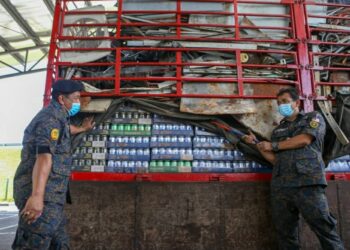 MOHD. Khairi Abdullah (kiri) bersama anggotanya menunjukkan  minuman keras yang dirampas pada sidang akhbar di Bukit Kayu Hitam, Kedah, hari ini. - UTUSAN/SHAHIR NOORDIN