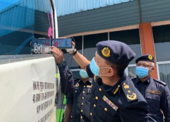 ADENAN Md. Isa (kanan) melakukan pemeriksaan cermin gelap kenderaan persendirian dalam Operasi Khas di Butterworth, Pulau Pinang, semalam. - UTUSAN/SITI NUR MAS ERAH AMRAN