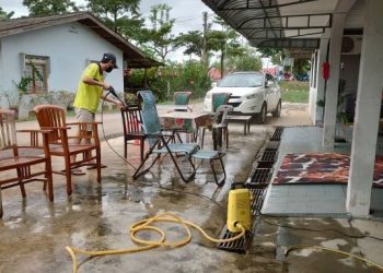 AFIQ Suhaimi melakukan kerja-kerja pembersihan selepas kediamannya di Kampung Paya Kenangan dilanda banjir.