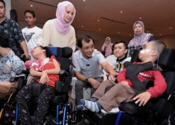 AHMAD Idham Ahmad Nadzri bersama isteri Jameah Abd. Aziz (berdiri, tengah) beramah mesra dan menyantuni anak-anak kurang upaya pada Majlis Makan Tengah Hari dan Ramah Mesra Komuniti Hab Pendidikan Khas Dr. Ahmad Idham di Port Dickson, hari ini. - FOTO/MOHD. SHAHJEHAN MAAMIN