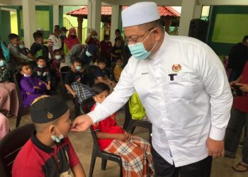 AHMAD Marzuk Shaary menyuap pulut kuning kepada kanak-kanak yang bakal dikhatankan di Dewan Pasti Kedai Buluh, Kota Bharu hari ini. - FOTO/ROSLIZA MOHAMED