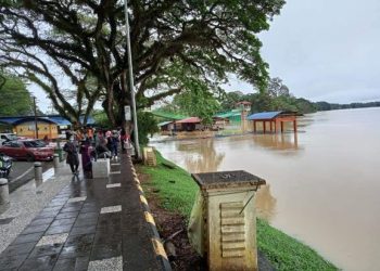 PENDUDUK meninjau keadaan Sungai Pahang di Taman Esplanade Temerloh yang semakin mencecah tebing meskipun cuaca tidak hujan di daerah itu sejak pagi tadi. - FOTO/MOHD. SHAHRULANOOR ISHAK