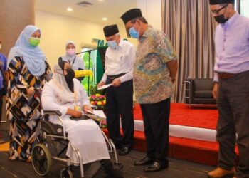 AMINUDDIN Harun menyampaikan sumbangan kepada asnaf pada Program Menteri Bersama Asnaf Daerah Seremban di Dewan Menara MAINS, Seremban, hari ini. - FOTO/MUHAMMAD IZZAT TERMIZIE