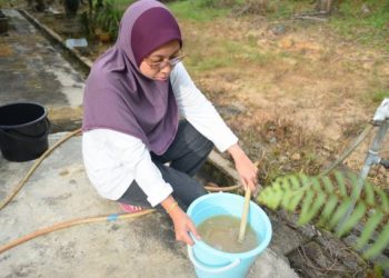 ARSYAFIERA Arshad menunjukkan bekalan air paip AKSB berwarna kekuningan dan berbau di rumahnya di Taman Hidayat, Machang, Kelantan, hari ini. - FOTO/BAHRUDDIN HATTA