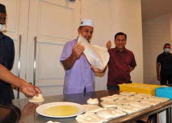 AYOB Khan Mydin Pitchay (dua kiri) menebar roti canai sambil diperhatikan Mohamad Fauzi Ishak (kanan) pada penutup Program Singgah Sahur KMJ di IPK Johor. - FOTO/RAJA JAAFAR ALI