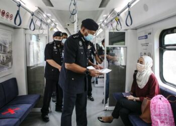 BAHARUDIN Mat Taib beramah mesra bersama penumpang menaiki keretapi komuter menghala ke Padang Jawa sewaktu tinjauan SOP PKP 3.0 pada pengangkutan awam di Komuter Seksyen 19, Shah Alam, Selangor, hari ini. - FOTO/ZULFADHLI ZAKI