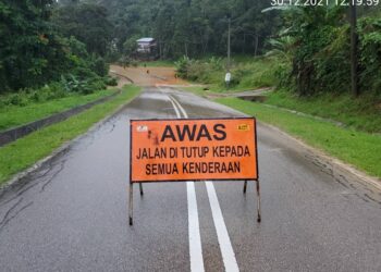 JALAN Jeli Lama dinaiki air sedalam hampir satu meter di laluan sejauh 650 meter dan terpaksa ditutup kepada semua jenis kenderaan hari ini. - IHSAN JKR JELI