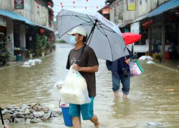 PENDUDUK Bazar Siniawan di Kuching, Sarawak berpindah selepas rumah mereka dinaiki air ekoran keadaan banjir yang semakin buruk. -UTUSAN/ALICIA JOHNY KUEH