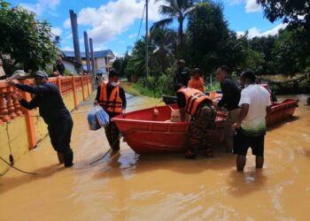 ANGGOTA bomba bertungkus-lumus membantu memindahkan mangsa banjir ke tempat selamat di Temerloh. - IHSAN BOMBA