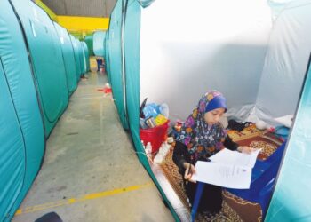 SITI Nur Aina Qaisara SH Hairul Anuar mengikuti sesi persekolahan secara PdPR di dalam khemah di PPS SK Sri Pandan, Parit Raja, Batu Pahat, Johor. - UTUSAN/RAJA JAAFAR ALI