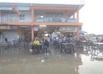 PELANGGAN bersarapan pagi di sebuah kedai makan di Jalan Pasar, Teluk Intan yang dinaiki air berikutan fenomena air pasang besar pagi ini. - FOTO/AIN SAFRE BIDIN