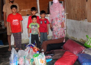 MOHD. Rizal Amran (belakang, kiri) bersama-sama empat anaknya menerima sumbangan daripada Nurul Farhana Simin (kanan) yang mewakili MBD Pontian di Kampung Rambah. Pemberita/Gambar: MUHAMMAD ZIKRI