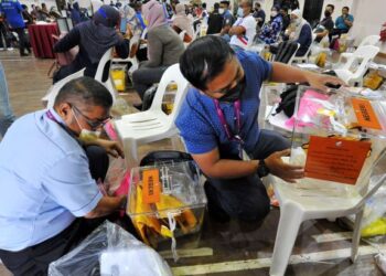 Petugas SPR menampal pelekat pada peti undi sebagai persiapan menghadapi Pilihan Raya Negeri Johor ke-15 hari ini di Dewan JKR, Johor Bahru. UTUSAN/RAJA JAAFAR ALI