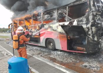 ANGGOTA bomba memadam kebakaran bas ekspres di R&R Ladang Bikam dekat Bidor hari ini. - UTUSAN/IHSAN JBPM PERAK