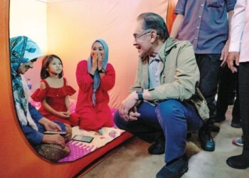 Anwar Ibrahim bertanya khabar sebahagian daripada mangsa banjir ketika 
melakukan lawatan ke pusat pemindahan sementara di Sekolah Menengah Kebangsaan Tengku Panglima 
Raja, Pasir Mas, Kelantan, semalam. – PEJABAT PERDANA MENTERI