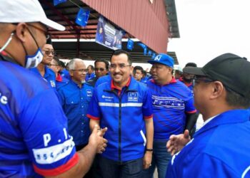 ASYRAF Wajdi Dusuki beramah mesra bersama para penyokong ketika hadir pada pelancaran jentera pilihan raya BN Parlimen Sepang di Kompleks Muhibah Tanjung Sepat, Selangor. -UTUSAN/FAISOL MUSTAFA