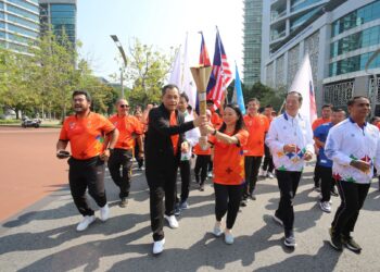 HANNAH Yeoh (dua, kanan) membawa obor Sukan SEA 2023 bersama Hamidin Mohd. Amin dalam Larian Obor Sukan SEA 2023 di Putrajaya Jaya hari ini. Turut kelihatan Hor Sarun (dua, kanan). - IHSAN MOM