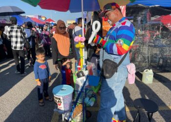 MOHD. SHAHRIZAL Isa menyediakan belon kepada kanak-kanak yang berkunjung ke bazar Ramadan Bertam Putra, Kepala Batas, Pulau Pinang. - pix: SITI NUR MAS ERAH AMRAN