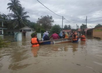 ANGGOTA APM membantu petugas Klinik Kesihatan Chikus memindahkan fail dan peralatan perubatan ke tempat selamat berikutan banjir di kawasan berkenaan di Teluk Intan, Perak hari ini. - IHSAN APM