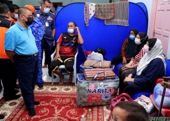 SAARANI Mohamad (kiri) berbual dengan mangsa banjir ketika melawat pusat PPS di Pejabat Kemas Muallim, Slim River, Perak hari ini. - FOTO/ZULFACHRI ZULKIFLI