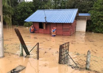 Anggota APM memantau keadaan penduduk Kampung Jimah Lama, Port Dickson yang terjejas banjir kilat pagi tadi.-UTUSAN/ZAKKINA WATI AHMAR TARMIZI