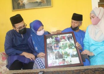 NORDIN Daud (dua dari kanan) dan isterinya, Zainab Ebar melihat gambar anak-anaknya sambil ditemani Noorani (kanan) dan Muhammad Amirul Hafiz (kiri) di rumah mereka di Kampung Lama, Benut, Pontian, Johor. – FOTO/MUHAMMAD ZIKRI