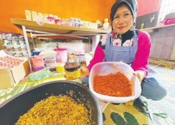 ROSLINA Mohd. Othman menunjukkan belalang goreng cheese yang semakin mendapat sambutan penggemar di rumahnya di Jalan Jeram Pasu, Padang Pak Amat, Pasir Puteh, Kelantan, semalam. – UTUSAN/TOREK SULUNG