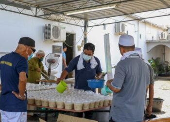 Kakitangan Masjid Zahir membungkus bubur lambuk untuk diedarkan dalam program Kongsi Berkat Bubur Lambuk anjuran EB Frozen Food dan Media Mulia Sdn. Bhd. di Alor Setar, kelmarin. – UTUSAN/ SHAHIR NOORDIN