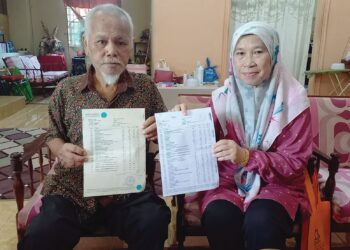 KAMIS Ahmad dan Jaliah Yusof menunjukkan bil rawatan berjumlah RM150,000 sewaktu mendapat rawatan Hospital Al Shefa Syarif Mansour, Mekah. - UTUSAN/AMRAN MULUP