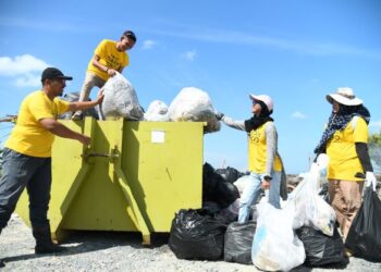 PARA sukarelawan NGO Pahlawan Sampah atau Trash Hero Perlis memastikan plastik-plastik sampah diikat dengan kemas supaya tidak bercampur dengan sisa-sisa selepas mengutip sampah di pesisir Pantai Kuala Sungai Baru, Perlis.-UTUSAN/IZLIZAN OTHMAN