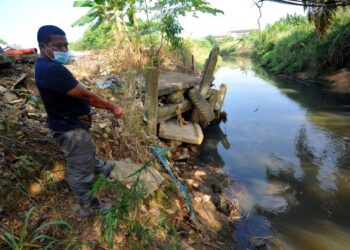 Seorang penduduk menunjukkan keadaan terkini Sungai Kim Kim di Kampung Bukit Pulai, Pasir Gudang, semalam. – UTUSAN/RAJA JAAFAR ALI