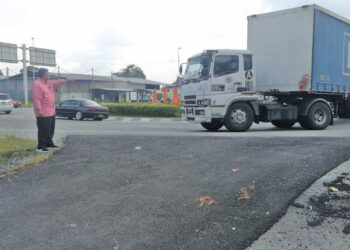 RAMLI Mohd. Atan menunjukkan kenderaan yang masuk ke Bulatan Pulau Carey tanpa berhenti terlebih dahulu dari arah Banting dan Pulau Carey menyukarkan penduduk kampung keluar dari kawasan rumah mereka di Jalan Klang - Banting di Kuala Langat, Selangor. - FOTO/ABDUL RAZAK IDRIS