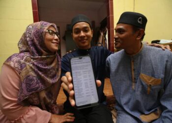 MOHAMAD Hakimi Ahmad Jais (tengah) berkongsi keputusan peperiksaan STAM dengan bersama ibu bapanya di Kampung Melayu Padang Grus, Lenggong, Perak, hari ini. 