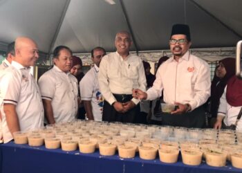 ADNAN Mat (kanan) pada program Ihya Ramadan gotong royong memasak dan edaran bubur lambuk AUEGCAS negeri Perak di Ipoh hari ini. - UTUSAN/LIYANA RAMLI