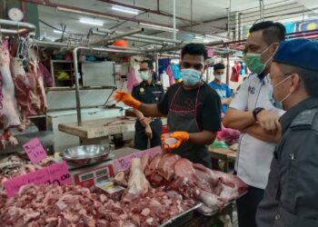 MOHD. Ridzuan Ab Ghapar (baju putih) bertanyakan sesuatu kepada penjual daging ketika melakukan tinjauan SHMMP di Pasar Awam Bayan Baru, Pulau Pinang.