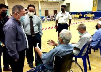 DR. Sirajuddin Hashim (kiri) beramah mesra dengan penerima vaksin fasa kedua Program Imunisasi Covid-19 Kebangsaan (PICK) di Pusat Pemberian Vaksin (PPV) Dewan Wawasan 2020, Kangar, Perlis hari ini. - FOTO/NAZLINA NADZARI