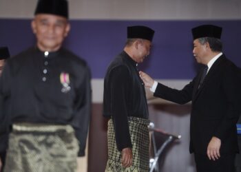 MOHAMAD Hasan (kanan) memakaikan anugerah Pingat Jasa Malaysia pada Majlis Penganugerahan PJM kepada seramai 450 orang veteran ATM, balu serta wakil waris yang diadakan di Wisma Perwira, Pangkalan Udara Sendayan, Seremban hari ini.-UTUSAN/MOHD. SHAHJEHAN MAAMIN